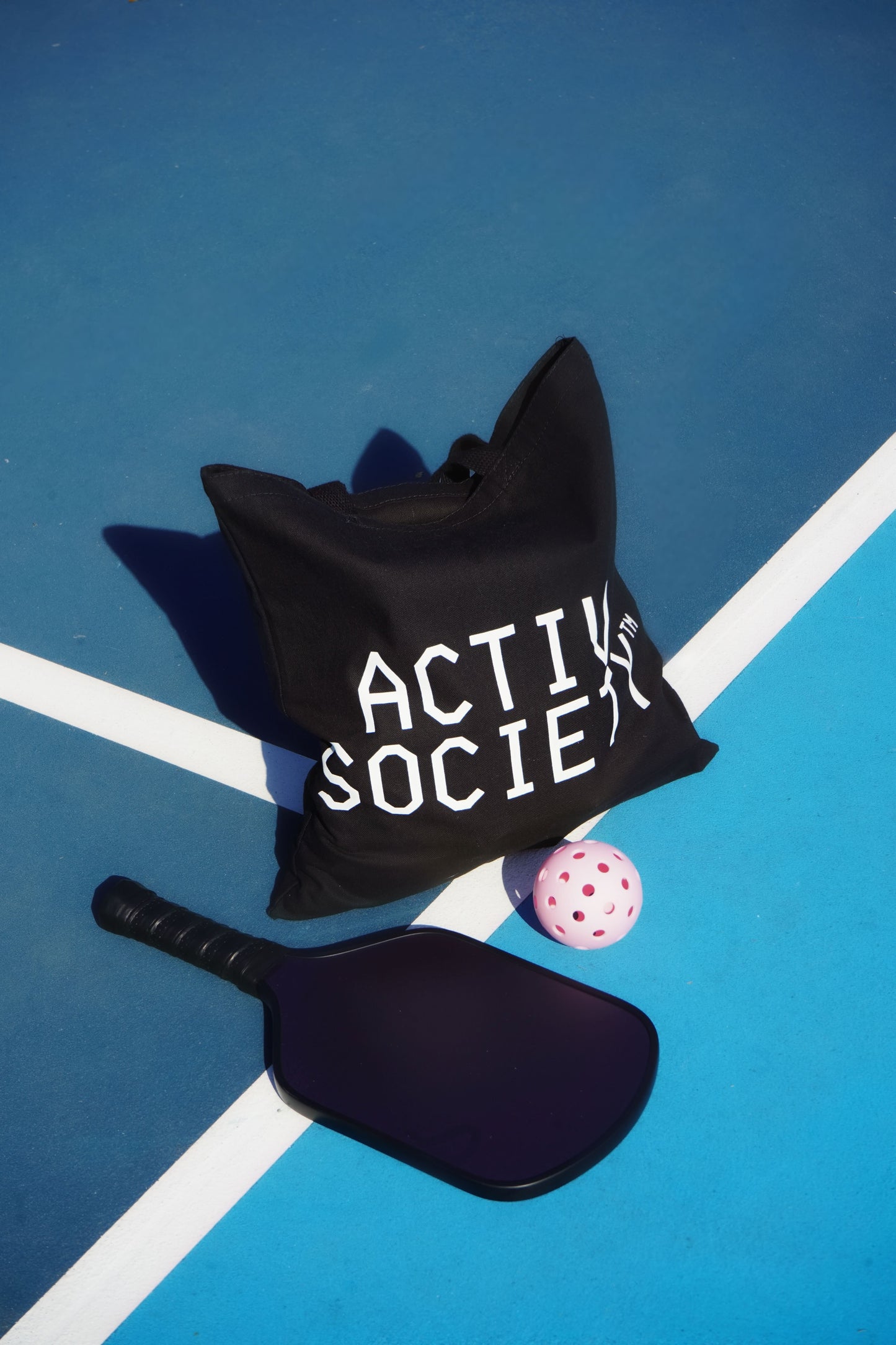 Black Activ Society tote bag on tennis court